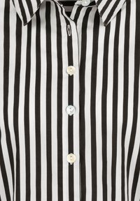 Black and white striped shirt featuring a collared neckline and button front, with light blue buttons and smooth fabric texture.