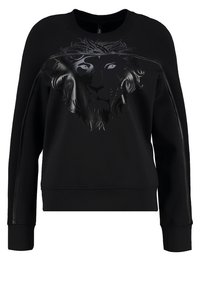 Sweat-shirt noir à manches longues avec motif en relief brillant de visage de lion sur le devant et panneaux en tissu texturé sur les manches et les épaules.