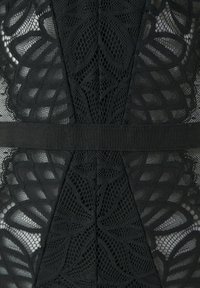 Melna mežģīņu audums ar sarežģītiem ziedu rakstiem, acs elementiem un gludu melnu apmalīti. Tekstūrēta apdare ir izteikta.