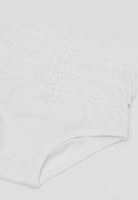 Mutande bianche in cotone impilate, caratterizzate da una morbida texture, una vita elastica e piccoli nastri decorativi all'anteriore di ciascun paio.