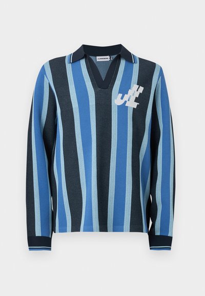 Polo en tricot à manches longues avec rayures verticales bleu et marine, col marine et initiales blanches stylisées sur la poitrine gauche.