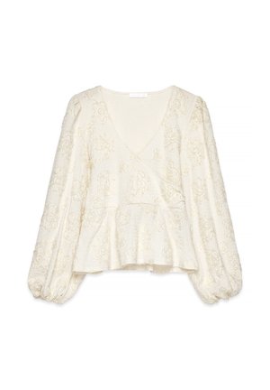 Cream long-sleeve blouse with V-neck, textured floral pattern, balloon sleeves, and peplum hem.