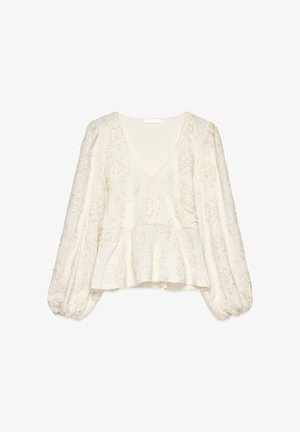 Krämfärgad blus med långa ärmar och V-ringning, texturerat blommönster, ballongärmar och peplumslut.