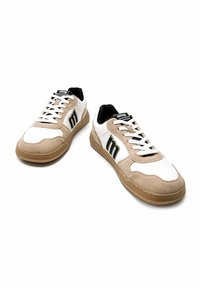 Zapatillas beige y blancas con parte superior de ante y cuero, acentos negros, detalles perforados y suela de goma. Incluyen cordones y logo.