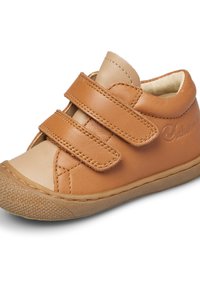 Sneaker in pelle marrone chiaro con due cinturini Velcro regolabili, punta tonda, suola in gomma testurizzata e dettagli cuciti. Parte superiore liscia e fodera morbida.