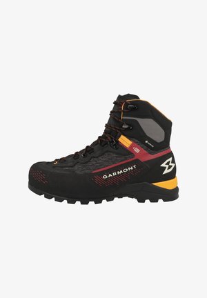 Bota de senderismo en negro y gris con acentos rojos, que presenta un upper texturizado, cierre de cordones y una suela resistente para tracción. Logotipo de Garmont visible.