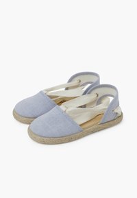 Espadrile albastre din pânză, cu șireturi elastice și tălpi din jute împletit. Au o margine cusută și o mică buclă decorativă pe călcâi.