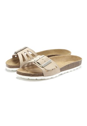 Las sandalias de ante beige presentan una amplia correa con un diseño recortado y una hebilla metálica, complementadas por una suela de corcho texturizada con acentos blancos.
