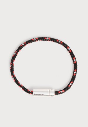Bracelet en cordon tressé noir avec des accents rouges et blancs et un fermoir cylindrique en argent gravé "le gramme".