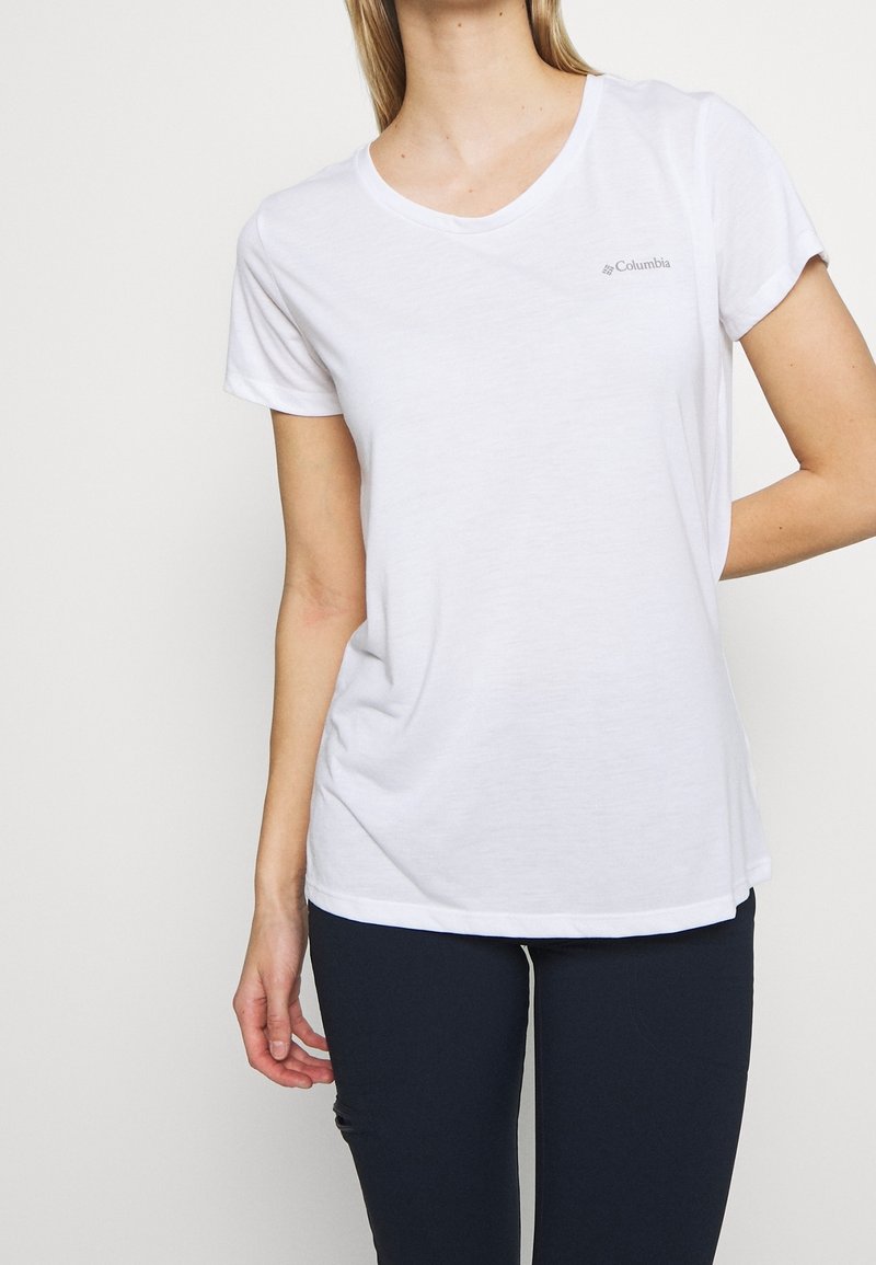 Vit kortärmad t-shirt med v-halsringning. Lättviktsmaterial. Inkluderar en liten Columbia-logotyp på vänster bröst. Avslappnad passform.