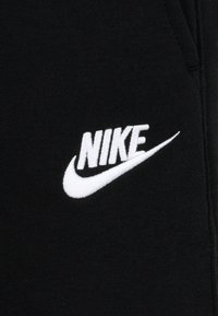 Tecido de sweatshirt preto com um destacado logótipo da Nike em branco bordado na frente, apresentando uma textura suave e um design limpo.