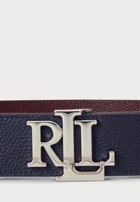Ceinture en cuir marine et bordeaux, ornée d'une boucle en métal argenté avec le logo 'RLL'. Surface texturée avec des détails en couleurs contrastées.