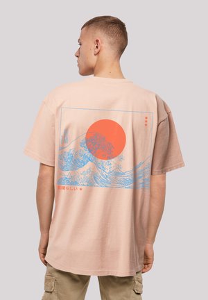 Tricou din bumbac, supradimensionat, de culoare piersică, cu un grafic în formă de val albastru, un soare portocaliu și text japonez pe spate. Mâneci scurte, material moale din bumbac.