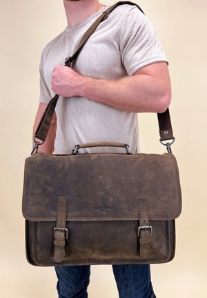 Braune Leder-Kuriertasche mit verstellbarem Schultergurt, Metallbeschlägen und zwei Schnallenverschlüssen. Glatte Textur mit matter Oberfläche.