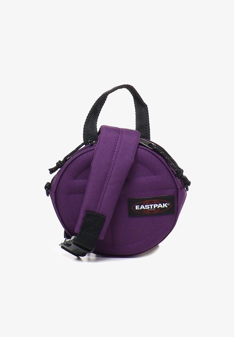 Borsa rotonda viola realizzata in tessuto resistente. Dispone di una maniglia superiore e di una tracolla regolabile, con chiusura a zip e patch con logo.