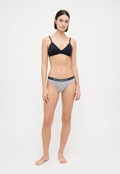 Bralette triangulaire noire avec des bretelles réglables, associée à un slip gris avec une taille élastique noire et un détail de logo.