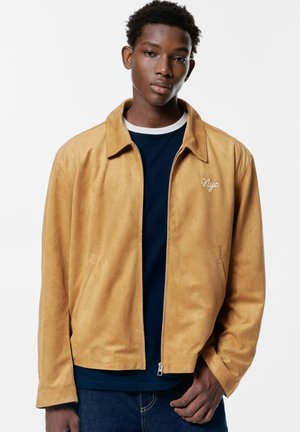 Jacka i konstläder - mustard yellow