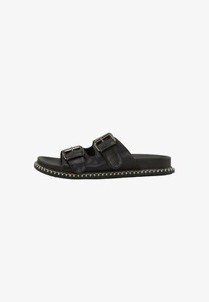 Sandalia negra tipo slide con dos tiras ajustables con hebillas y detalles de costura blanca alrededor de la suela.