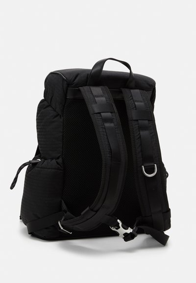 Zaino nero con tessuto imbottito, schiena in rete, spallacci spessi e accenti in metallo argentato. Dotato di una maniglia superiore e spallacci regolabili.