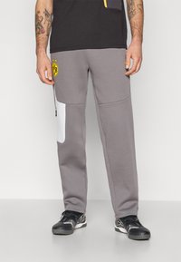Grå sweatpants med hvid paneldetalje, elastisk talje og logo-patch. Har en slank pasform og blødt stof for komfort.