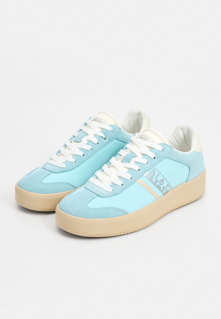 Zapatillas de ante azul con cordones blancos, suelas de goma beige y una franja decorativa en el lateral. Diseño elegante con puntera redondeada.