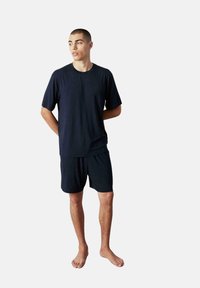 Conjunto de loungewear de algodón azul marino que incluye una camiseta de manga corta y pantalones cortos a juego, con un ajuste relajado y una textura suave.