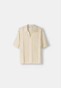 Camisa de manga corta beige con cuello, que presenta un patrón de punto texturizado y rayas verticales, confeccionada con un material suave y ligero.