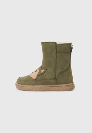 Grüne Wildlederschuhe mit einem tanfarbenen Tiergesicht-Patch, strukturiertem Gummisohle und einem seitlichen Reißverschluss für einfaches An- und Ausziehen. Niedrige Höhe, schlichtes Design.