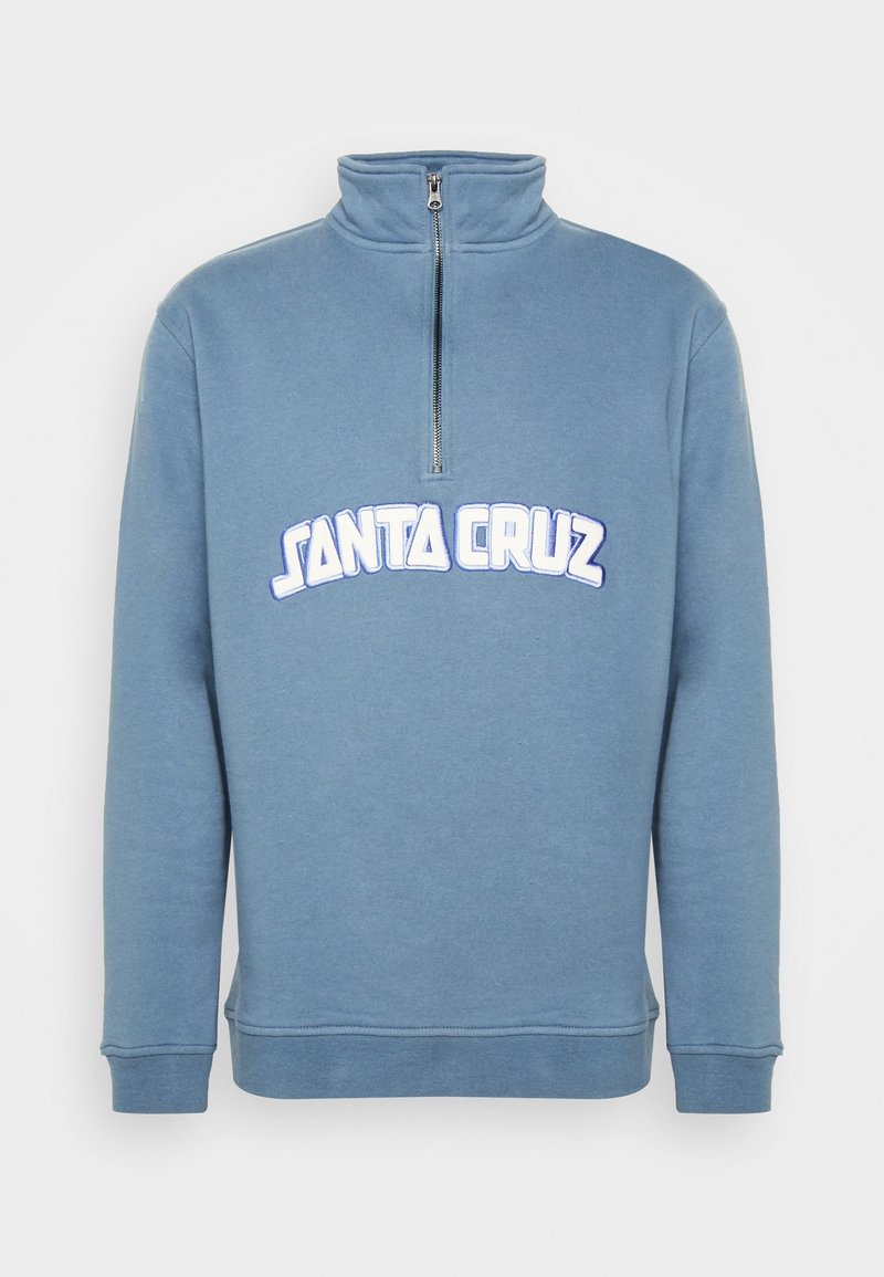 Pull-over à manches longues bleu avec col à fermeture éclair partielle et texte blanc "Santa Cruz" sur la poitrine.
