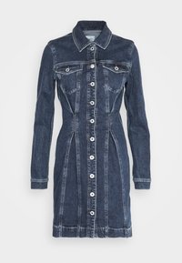 Denim kostüüm pikkade varrukatega, nööpidest ees ja kahe rindkere taskuga. Tumedat sinist värvi, heledamate õmblustega ja vormitud siluett.