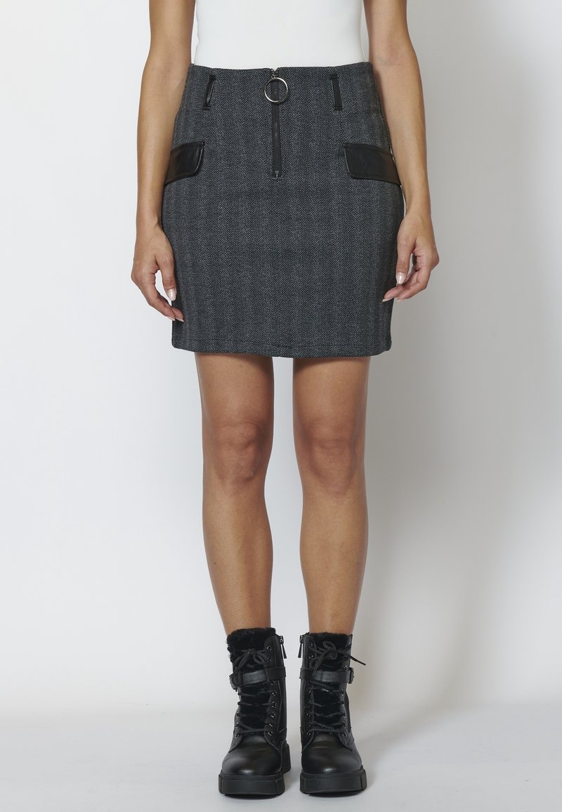 Svetle šedé houndstooth mini sukně s předním zipem a detailem ve tvaru kroužku, obsahující dvě černé kapsy z umělé kůže. Kombinováno s černými šněrovacími botami.
