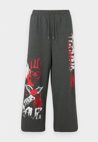 Graue Sweatpants mit lockerem Sitz, mit grafischen Drucken in Rot und Weiß, darunter ein Hase und dekorative Spritzer. Elastischer Bund.