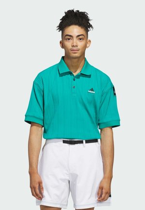 Polo shirt teal con texture a coste, con bottoni e dettaglio del logo; abbinato a pantaloni corti bianchi e una cintura nera.
