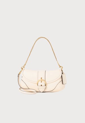 Sac à main en cuir crème avec une anse en chaîne dorée, de forme arrondie, et une fermeture à rabat avec une boucle circulaire. Surpiqûres noires et étiquette incluses.
