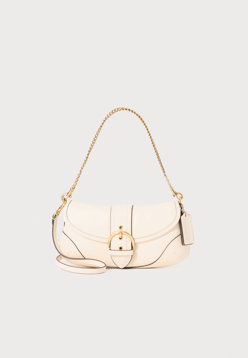 Cream leather handbag with a gold chain strap, rounded shape, and flap closure featuring a circular buckle. Black accent stitching and tag included.