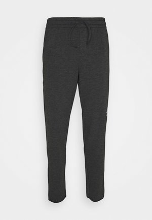 Tmavohnedé tepláky s elastickým pásom, šnúrkou a zoštíhlenými nohavicami. Mäkká tkanina s minimálnym brandingom na ľavom stehne.