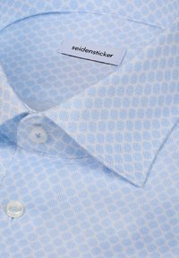 Lichtblauw overhemd met patroon, voorzien van een spitse kraag, knoopsluiting en een zachte textuur. Het label draagt de naam "seidensticker."