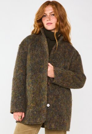 Veste surdimensionnée en mélange de laine aux teintes vertes, brunes et bleues variées ; elle présente un col, deux grands boutons et des poches appliquées.