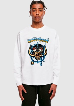 White long-sleeve t-shirt featuring a colorful graphic of a skull wearing a spiked helmet, with chains and details in blue, gold, and red.