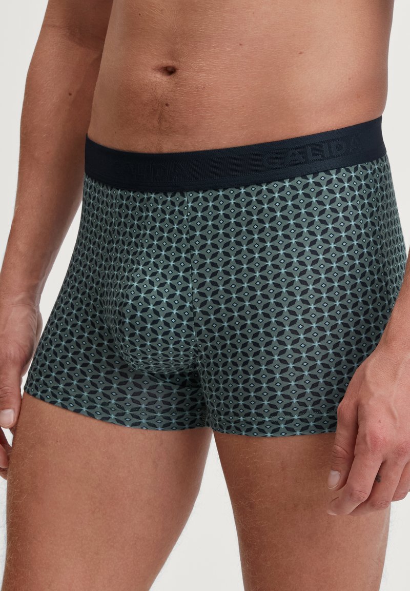 Heren boxershorts met een donkerblauw geometrisch patroon, elastische tailleband en zachte stof. Het ontwerp bevat hexagonale vormen en accenten.