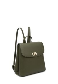 Zaino in pelle verde oliva con pattina frontale, hardware dorato e dettaglio cucito. Presenta due spallacci regolabili.