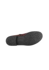 Chaussure en cuir marron avec une semelle en caoutchouc noir texturé ; présente un design flexible et un branding subtil sur la semelle.