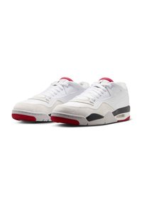 Scarpe da ginnastica bianche in suede e rete, con un accento rosso sulla suola e sulla linguetta, e un dettaglio nero nel tallone.