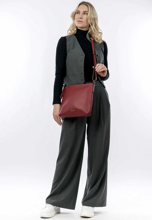 Red leather crossbody bag with a textured finish, featuring a sleek rectangular shape, adjustable strap, and subtle branding.