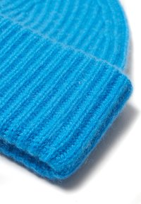 Niebieska prążkowana dzianinowa czapka wykonana z miękkiej wełny. Posiada podwinięty brzeg, teksturowany wzór oraz intensywny kolor.