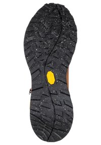 Schwarze, robuste Schuhsohle mit tiefen Profilen, dreieckigen Mustern und einem gelben Vibram-Logo in der Mitte.