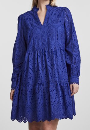 Blue long-sleeve dress with eyelet lace fabric, high ruffled collar, tiered skirt, and scalloped hem worn by a person shown from neck to mid-thigh.