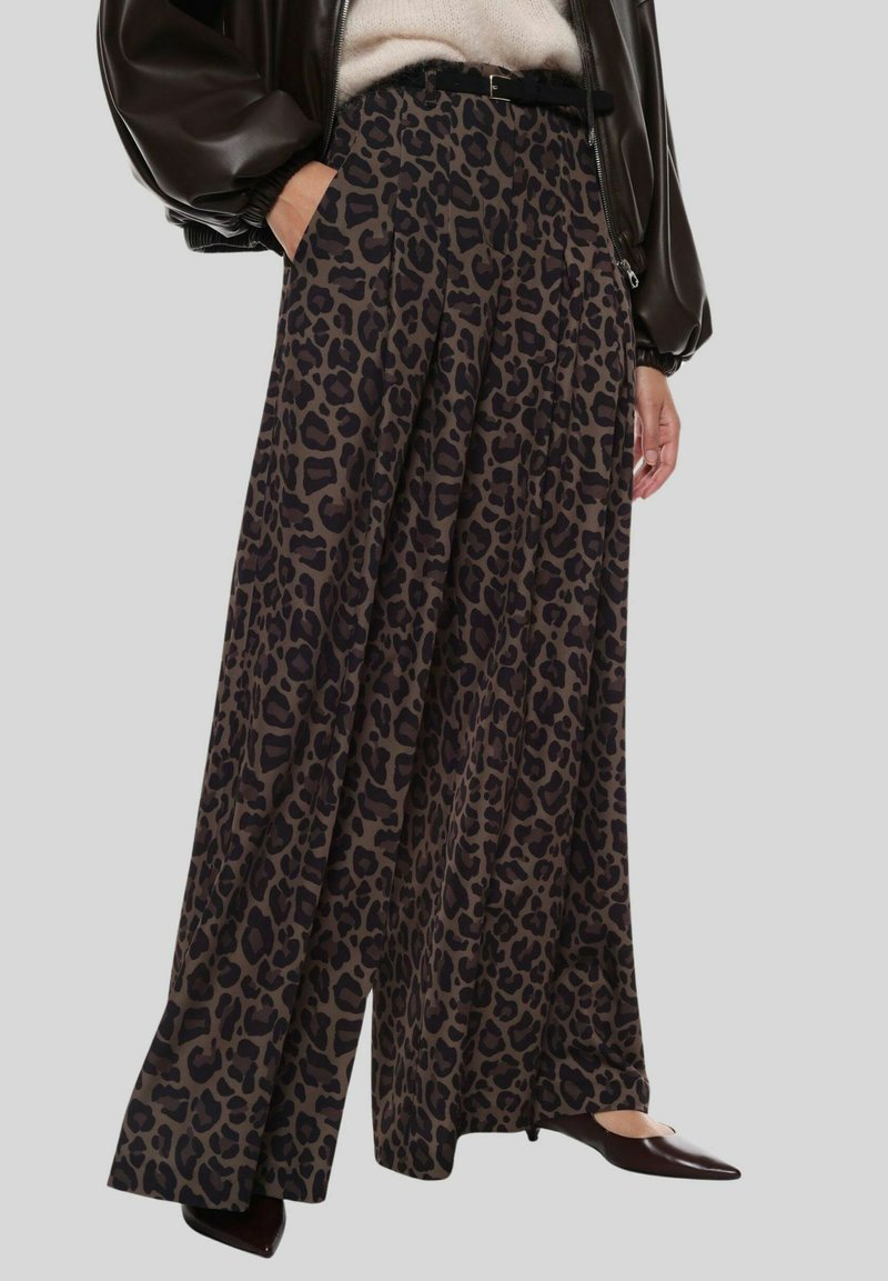 Pantaloni a gamba larga con stampa leopardata in tessuto marrone scuro e nero, caratterizzati da pieghe e vita alta, abbinati a una cintura nera e scarpe con punta.