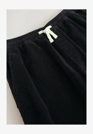 Schwarze Corduroy-Sweatpants mit gerippter Textur, ausgestattet mit einem elastischen Bund und einer weißen Kordel zur Anpassung.