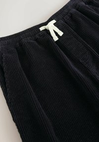 Zwarte corduroy broek met een gestructureerd oppervlak, elastische tailleband met witte trekkoord en twee zijzakken.